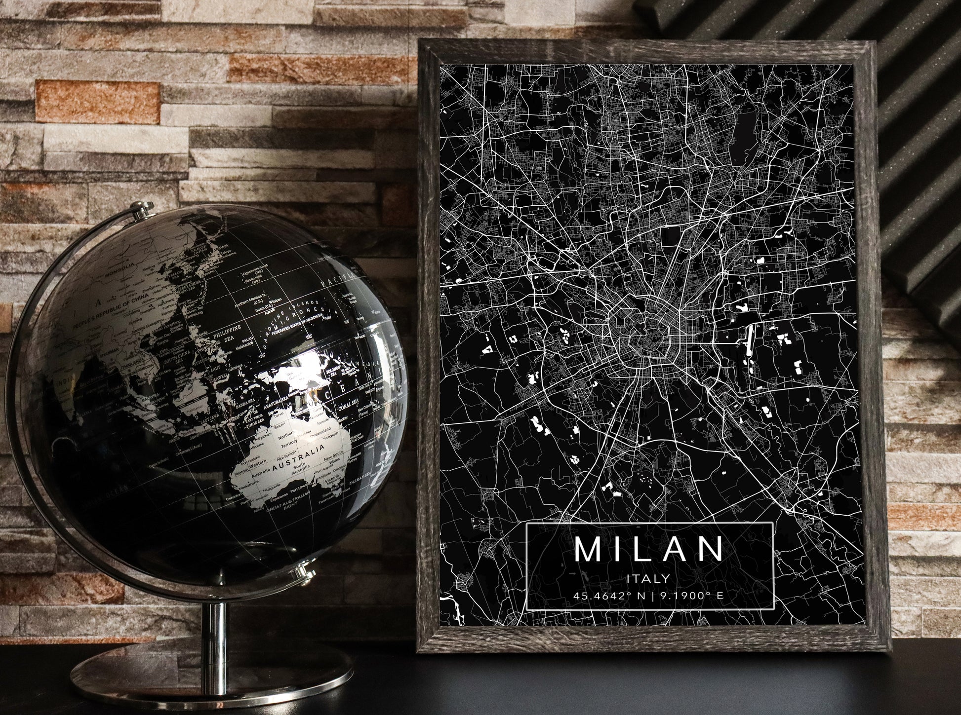 Black and white map print of Milan, Italy. The dark background highlights the city's street layout and landmarks, with coordinates listed beneath the city name