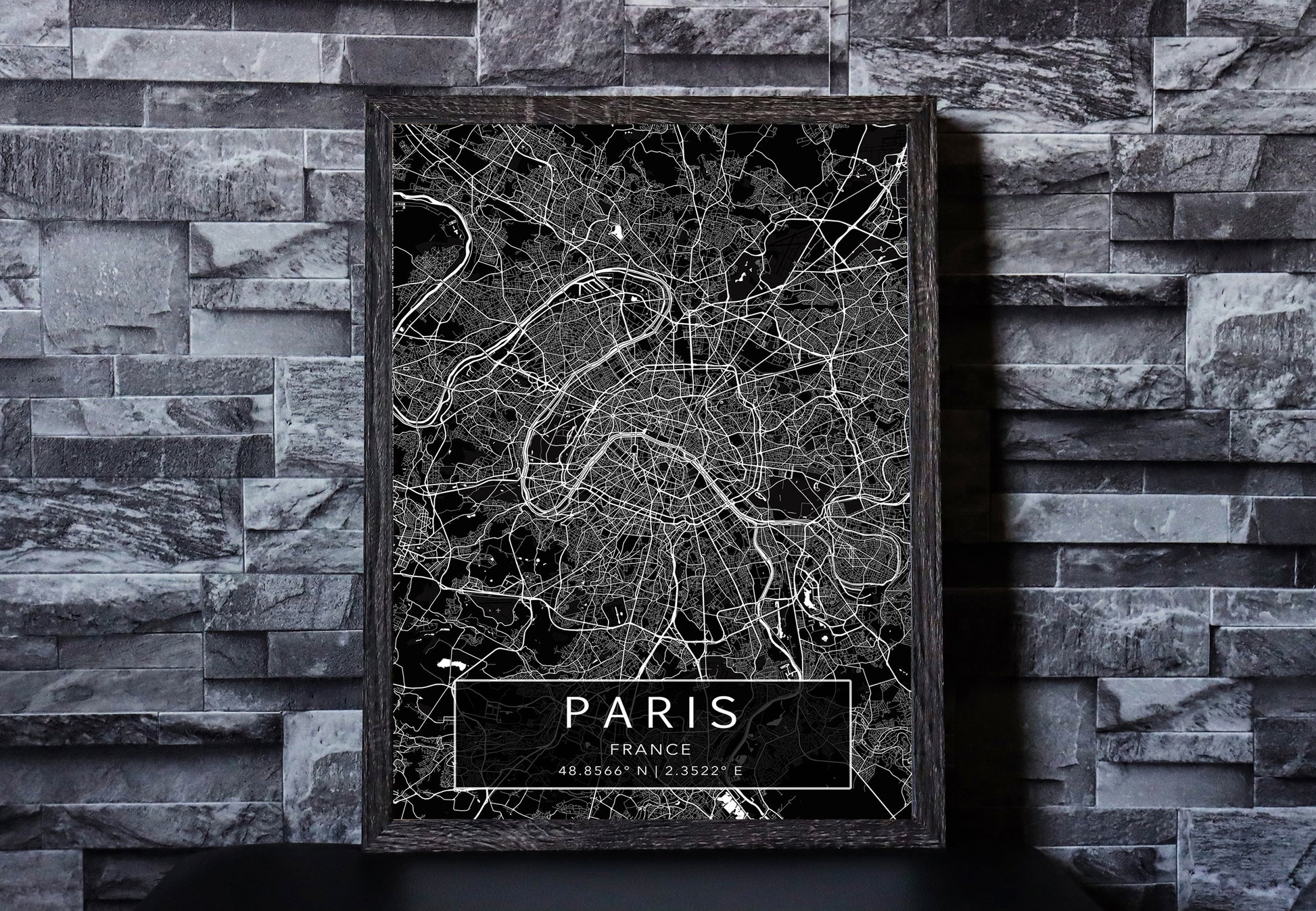 Black and white map print of Paris, France. The dark background highlights the city's street layout and landmarks, with coordinates listed beneath the city name.